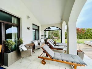 巴尔奇克Private seaview villa in BlackSeaRama - 1st line的门廊上设有带沙发和椅子的庭院