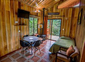 蒙泰韦尔德哥斯达黎加Cabañas Hoja Verde的卧室配有一张床和一张桌子
