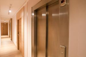 桑亨霍卡里布萨克森酒店的大楼内带金属电梯的走廊