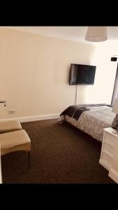 罗奇福德Ac lounge36 (B)的卧室配有一张床,墙上配有电视。