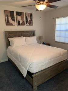 奥本代尔Florida Oasis的卧室配有一张白色大床和吊扇