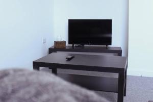 海伍德Comfy 1BR Apartment with Great Amenities的客厅配有电视和茶几