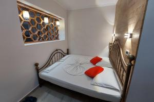 伏罗拉villa Heljos apartaments的小卧室配有带2个橙色枕头的床