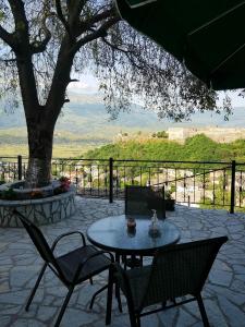 吉诺卡斯特Panoramic Vlachos的一个带桌椅和树的庭院