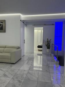 瓦伦西亚DeLuxe House Valencia的客厅配有白色沙发和蓝色灯光
