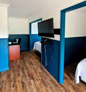 SchreiberThe Voy的卧室拥有蓝色的墙壁,配有电视和床。