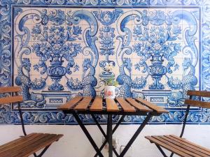 埃武拉Old Évora Hostel的蓝白色墙前的一张桌子和两把椅子