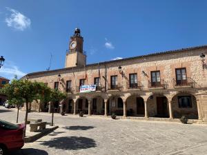 巴尔德韦德哈Pensión Valdeverdeja - Entorno Rural y Natural - Castilla La Mancha的一座大型砖砌建筑,顶部设有钟楼