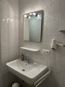莱比锡Pension Lydia的白色的浴室设有水槽和镜子