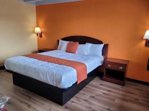 诺沃克Espana Motel的酒店客房,设有一张带橙色墙壁的大床