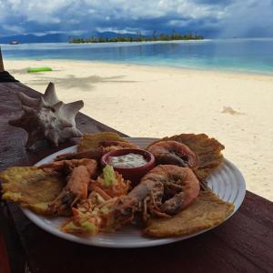 AchoertupoStay San blas islands private room的海滩上的餐桌上放着一盘海鲜