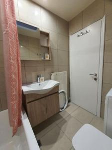 科斯镇Livas City Relaxing Apartment的一间带水槽、卫生间和门的浴室