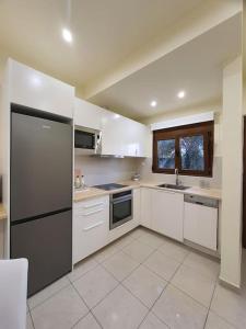 科斯镇Livas City Relaxing Apartment的厨房配有白色橱柜和黑色冰箱。