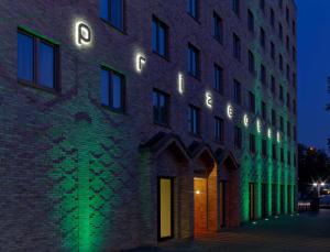 汉堡汉堡城普利泽特酒店的一座砖砌的建筑,晚上有灯