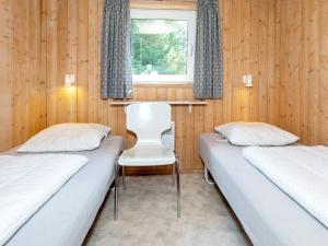 图鲁普斯特兰德Three-Bedroom Holiday home in Fjerritslev 21的配有木墙和窗户的客房内的两张床