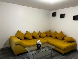 CLAREN appart 57的客厅里一张黄色的沙发,配有桌子