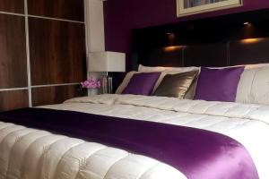 危地马拉Torre Pamplona 409 -Nuevo y Cómodo- Apartamento的卧室内的一张大床,拥有紫色的墙壁