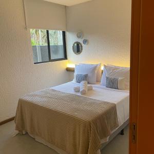 圣米格尔-杜斯米拉格里斯Villa Kamby Milagres B004的卧室配有一张带两个枕头的大白色床