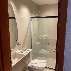 圣米格尔-杜斯米拉格里斯Villa Kamby Milagres B004的一间带卫生间和玻璃淋浴间的浴室