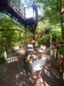 名户Treeful Treehouse Sustainable Resort的一个带椅子和火坑的木制甲板