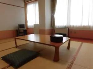 鱼沼市Asakusa Sanso的客厅,配有桌子和碗