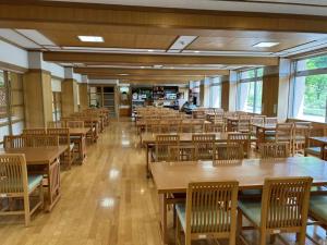 鱼沼市Asakusa Sanso的一间空的自助餐厅,配有木桌和椅子