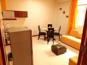 伊基托斯100 RV Apartments Iquitos-Apartamento primer piso con vista a piscina的一间带桌子的客厅和一间餐厅