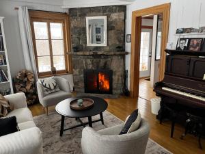 拉马巴耶Auberge musicale Pour un Instant的客厅设有壁炉和钢琴。