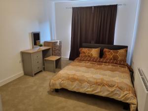 史云顿A Spacious and Hearty 2BD Swindon stay的一间卧室配有一张床、梳妆台和书桌