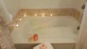 小石城Urban Cottages的浴室配有带蜡烛的浴缸。