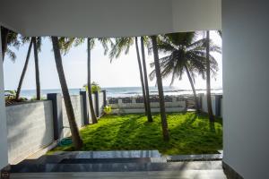 乌杜皮Reunion Ocean Manor - Beach House的棕榈树房屋享有海滩美景