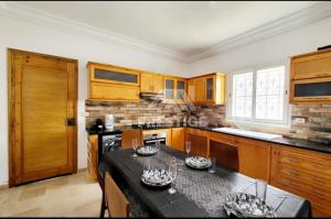 塔格梅斯Villa oussoua的厨房配有木制橱柜和黑色台面