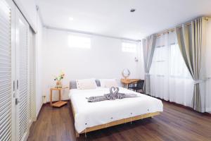 曼谷Ratchada Retreat Boutique Villa 1的卧室配有白色的床和大窗户