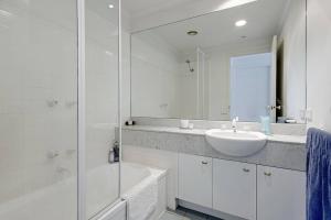 墨尔本Spacious apartment minutes from the CBD的白色的浴室设有水槽和镜子