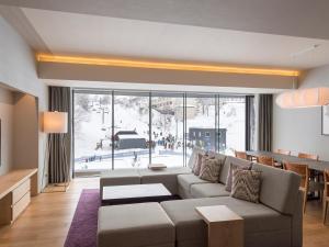 二世古新雪谷绫公寓式酒店的带沙发和大窗户的客厅