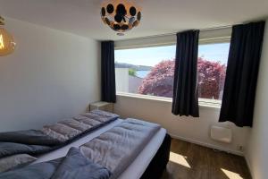 卑尔根Luxurious villa at Troldhaugen的一间卧室设有一张床和一个大窗户