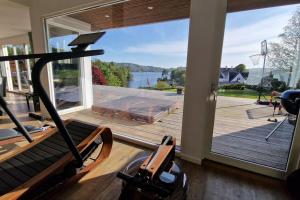 卑尔根Luxurious villa at Troldhaugen的一个带大窗户的健身房,享有水景