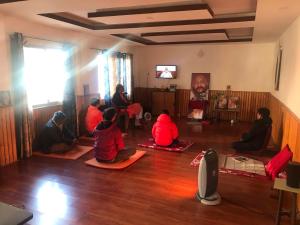 加德满都Osho Gaurishankar Meditation Center的一群人坐在一个房间里地板上
