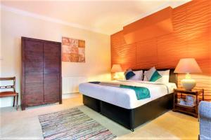 托基Yardley Manor Hotel的一间卧室配有一张大床和大型木制床头板
