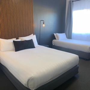 肯图巴Echo Point Discovery Motel的酒店客房设有两张床和窗户。