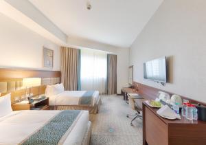 麦加Makkah Al Aziziah的酒店客房设有两张床和一台平面电视。