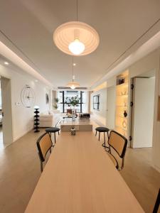 上海上海新天地奶油风超大客厅三卧室公寓的客厅配有一张大木桌和椅子