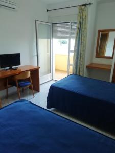 尼哈尔Hotel Balisa的一间卧室配有一张床、一张桌子和一台电脑