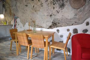 克鲁兹·德·特赫达Casa Cueva El Pedregal Tejeda的一间带木桌和椅子的用餐室