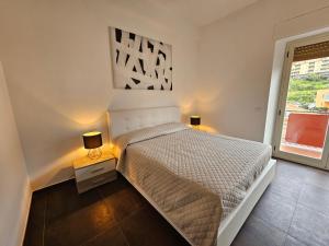 维博瓦伦蒂亚码头Residenza Atena的一间白色卧室,配有一张床和两盏灯