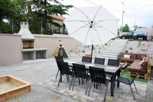 里耶卡Commodious house in Rijeka with 5 bedrooms的庭院配有桌椅和遮阳伞。