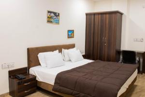 印多尔Hotel Kiwi Inn的一间卧室配有一张大床和一个木制橱柜