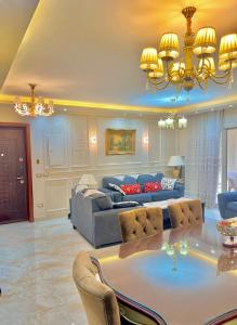 开罗Ultra Luxury 3BR with Pools ,Sports ,Dining in Gated compound, Close to all sites的客厅配有桌子和沙发