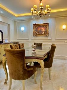 开罗Ultra Luxury 3BR with Pools ,Sports ,Dining in Gated compound, Close to all sites的一间带桌椅和吊灯的用餐室