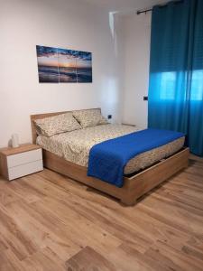 皮昂比诺Appartamento Perla di Mare的一间卧室配有床和蓝色窗帘